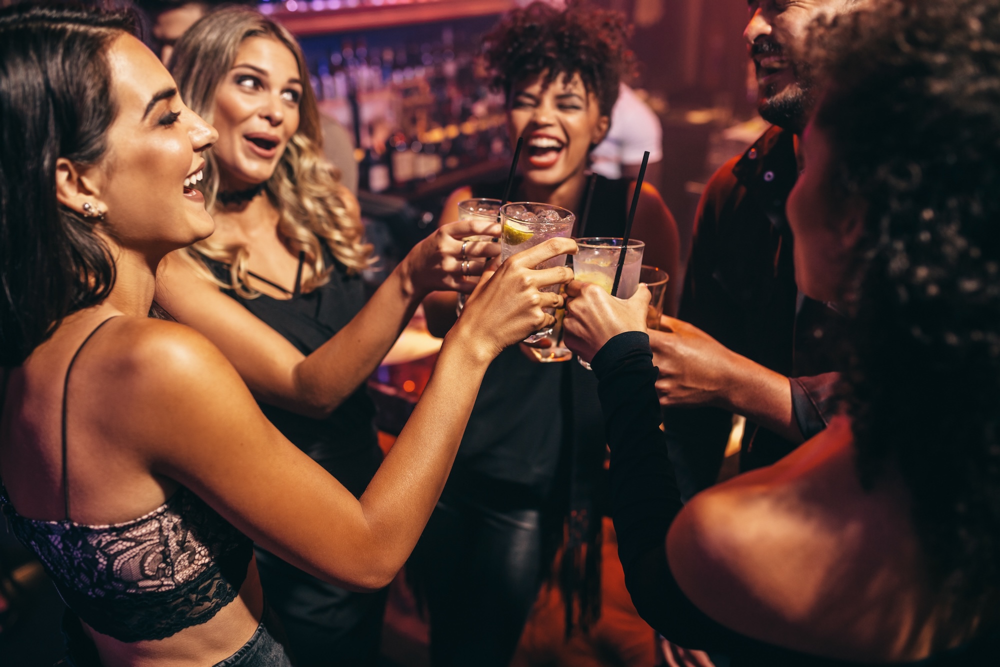 Friends cheering with cocktails inside one of Brickell’s late night bars, enjoying a lively and energetic nightlife atmosphere.