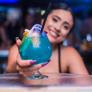 Smiling guest enjoying a signature Blue Martini cocktail at Blue Martini Fort Lauderdale.